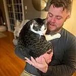 Shoulder, Beard, Comfort, Gesture, Felidae, Cat, Fawn, Companion dog, Dog breed, Lap, Whiskers, Small To Medium-sized Cats, Wood, Facial Hair, Event, Furry friends, Domestic Short-haired Cat, Formal Wear, Moustache